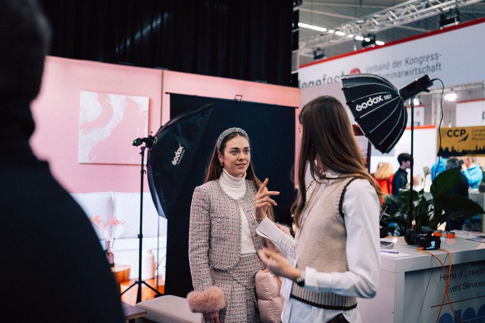 Fotoset auf einer Messe: Softbox, Hintergrund und zwei Personen im Gespräch am Stand von NudgeMe Coaching