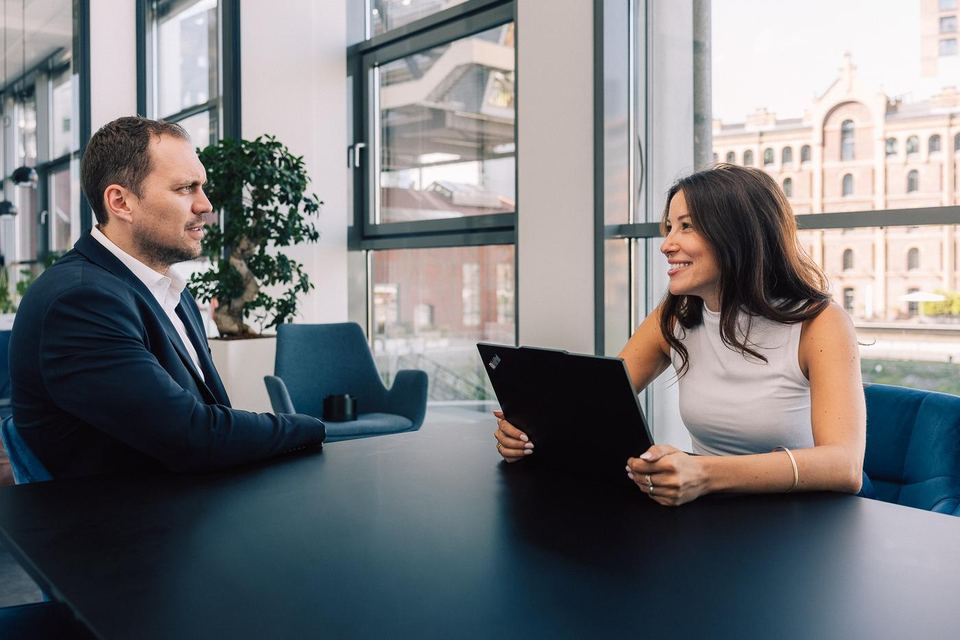 Berater und Beraterin im Gespräch am Besprechungstisch bei grynia consulting