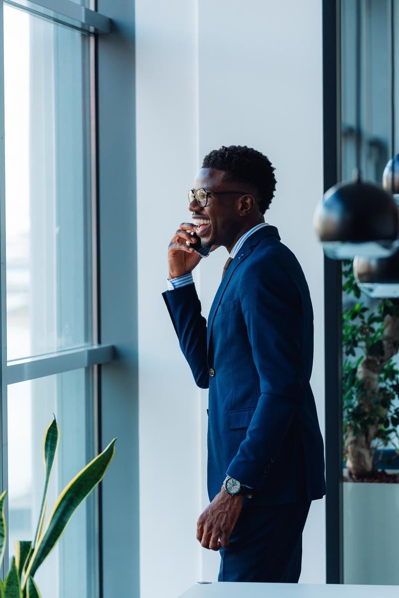 Junger Berater mit Brille telefoniert am Fenster im Büro von grynia consulting